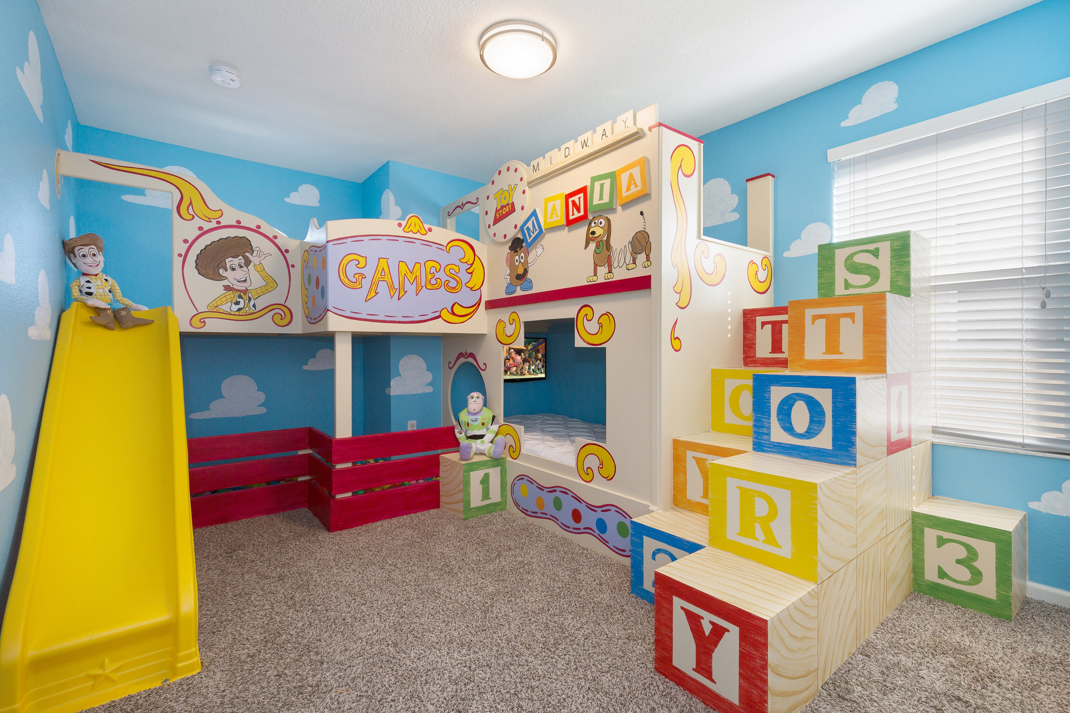 A custom-build children's bedroom that is toy-inspired with bunk beds, building blocks and a bed slide.