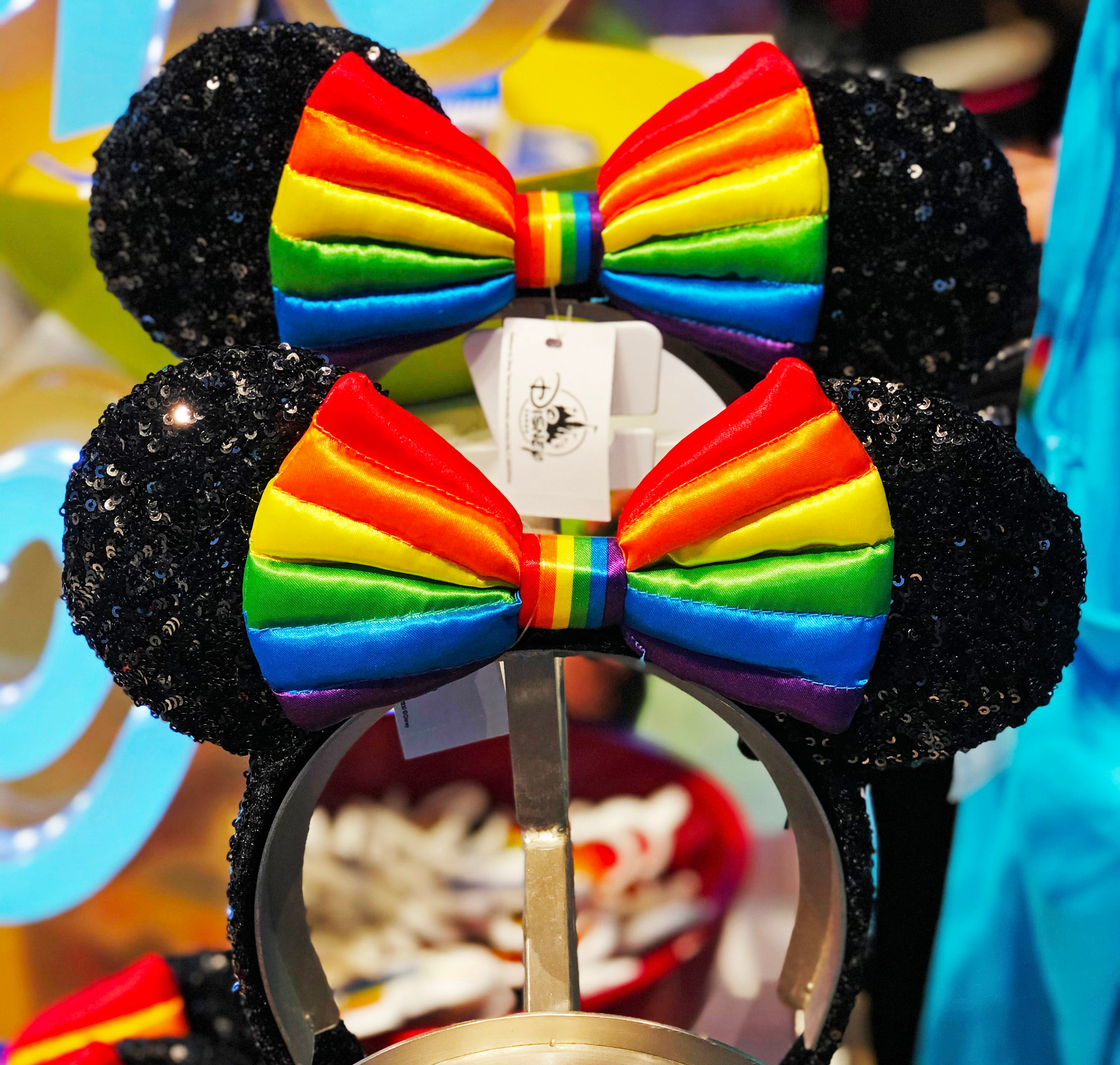 Rainbow Disney Collection Minnie Mouse Ear Headband, featuring a striped rainbow bow on black sequined minnie ears.
