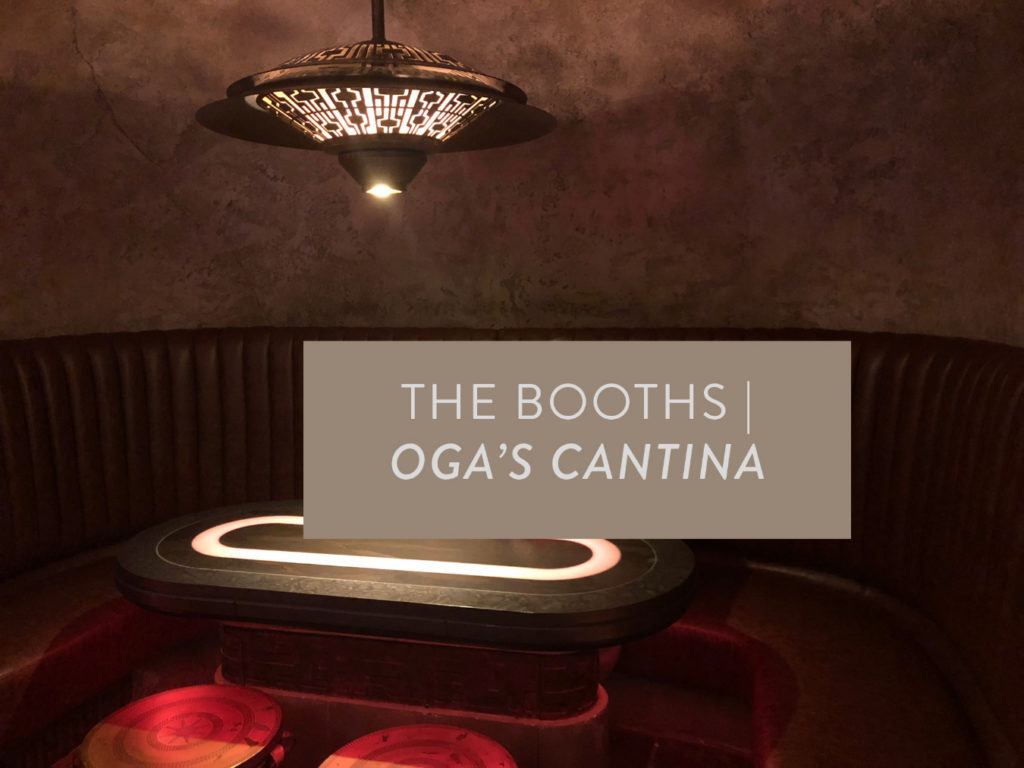 A dim-lit photo of the booths at Oga's Cantina inside of Star Wars: Galaxy's Edge at Disney's Hollywood Studios®. Boxed text placed over the booth to read what the photo is. Lake Buena Vista, Florida.