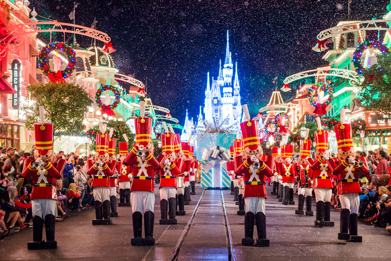 Nighttime shot of toy soldiers in band formation on a snowy Main Street U.S.A. in front of an lit-up icicle decorated Cinderella Castle at the Magic Kingdom® Park, Lake Buena Vista, Florida.