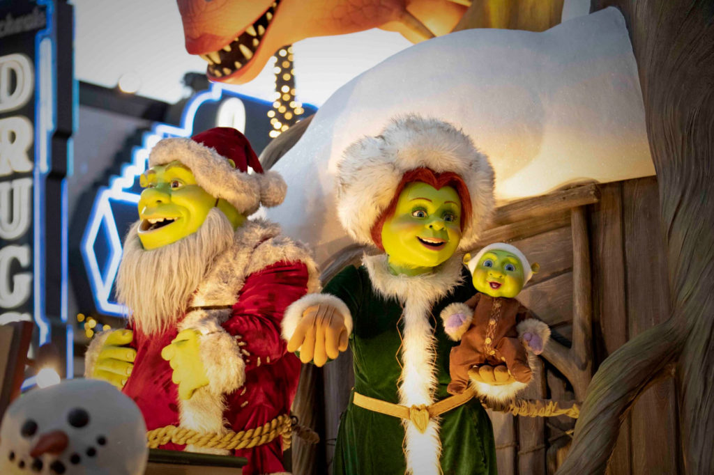 Shrek (left) and Princess Fiona (right) dressed as Mr and Mrs Claus while Fiona holds their baby on a Christmas float as part of the Macy's Christmas Day Parade in Universal Studios Florida.