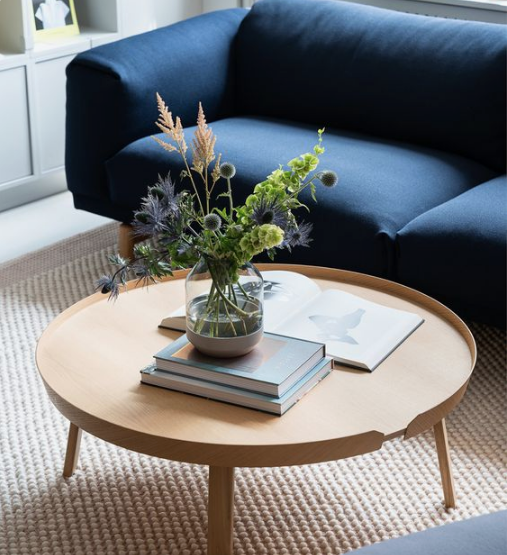Rounded table next to blue couch in living room