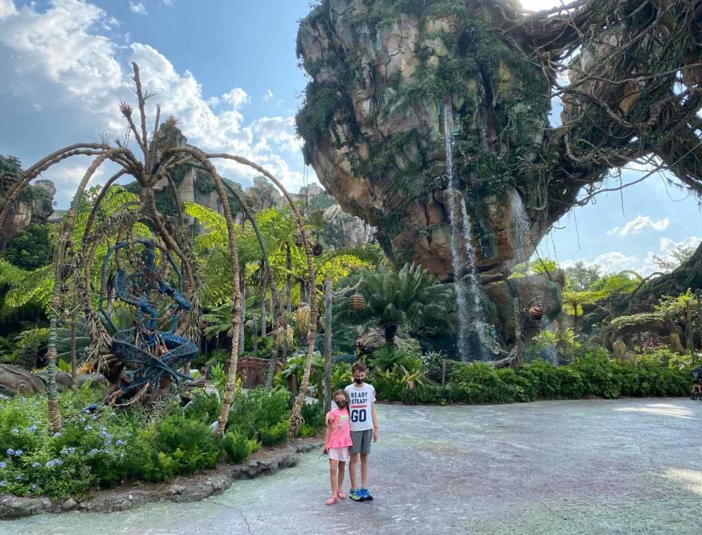Girl (left) and boy (right) pose in center of daytime shot photo in front of Pandora: World of Avatar inside of Disney's Animal Kingdom® Theme Park. Lake Buena Vista, Florida.